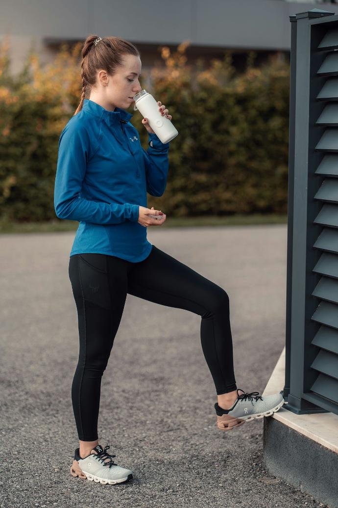 Afbeelding van een vrouw die water drinkt na het sporten