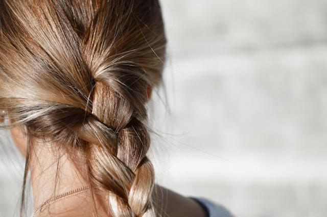 femme de dos cheveux blonds brillants avec une tresse
