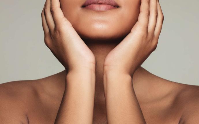 Visage femme épaules nues avec les mains en coupe sur les joues