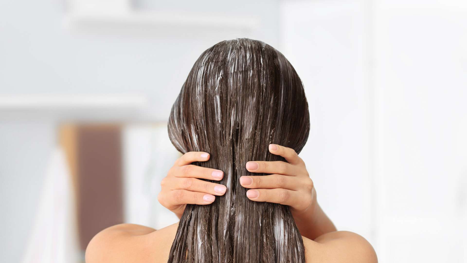 Frau von hinten mit Haarmaske auf ihrem Haar