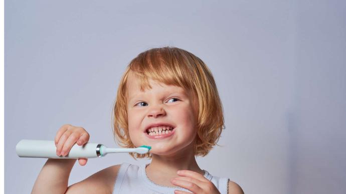 Petite fille rousse cheveux courts qui se brosse les dents