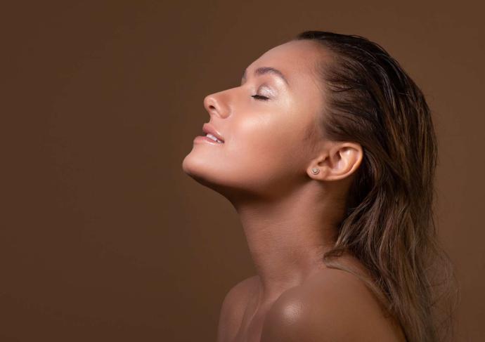 Visage de profil femme bronzée sur fond marron