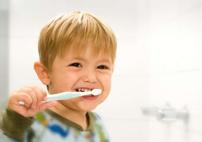 Petit garçon blond qui se lave les dents