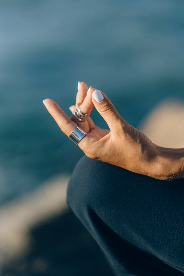 Main de femme avec bague et vernis bleu pâle pouce et index joints
