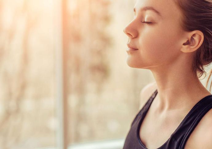 Jeune femme de profil qui respire les yeux fermés