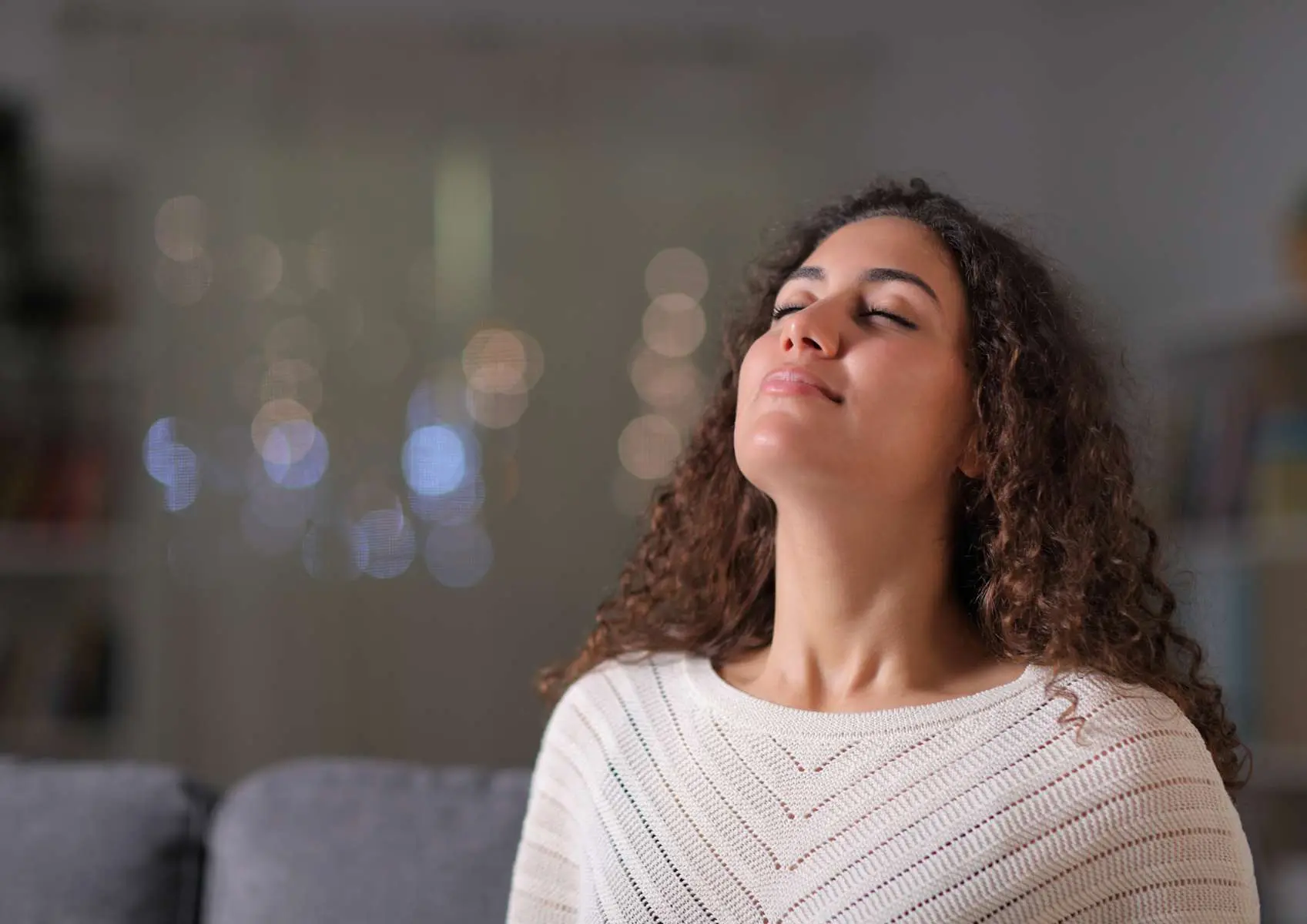 Jeunfe femme yeux fermés et sourire la tête vers le haut