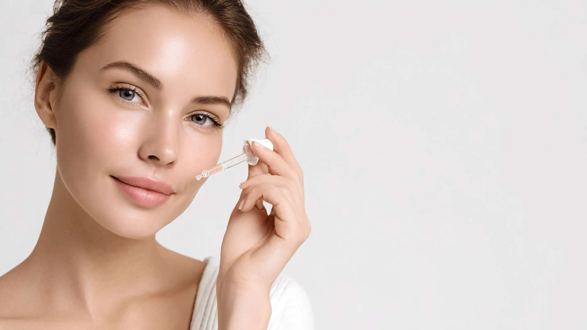Jeune femme qui applique du serum sur son visage