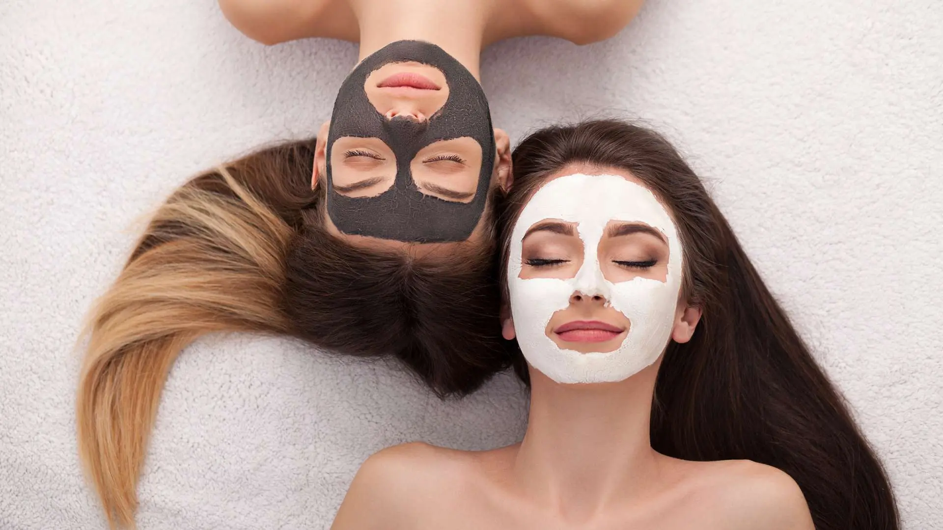 Vue de haut visages jeunes femmes têtes bêches avec masque à l'argile blanche et noire