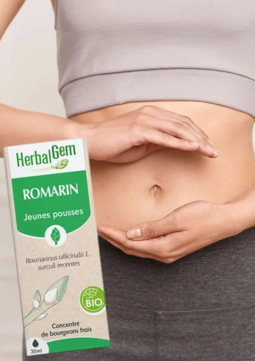 Gros plan ventre plat femme avec les mains en coup autour du nombril et boîte de bourgeon de romarin Herbalgem