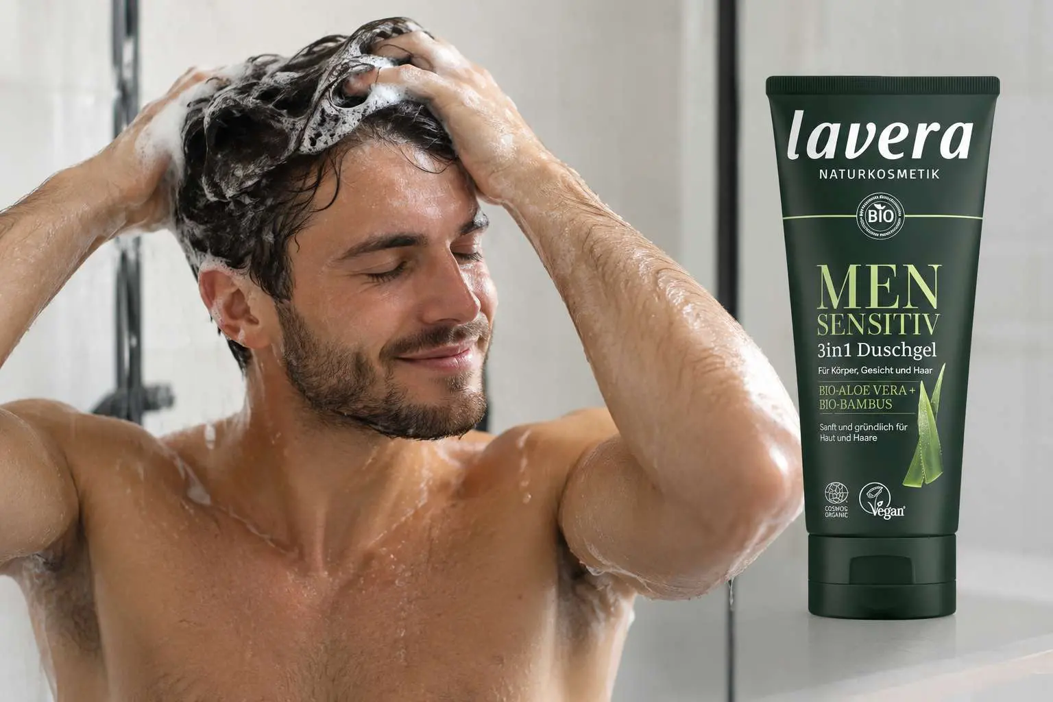 Homme se lavant les cheveux avec tube de gel douche 3 en 1 Mens Sensitive Lavera