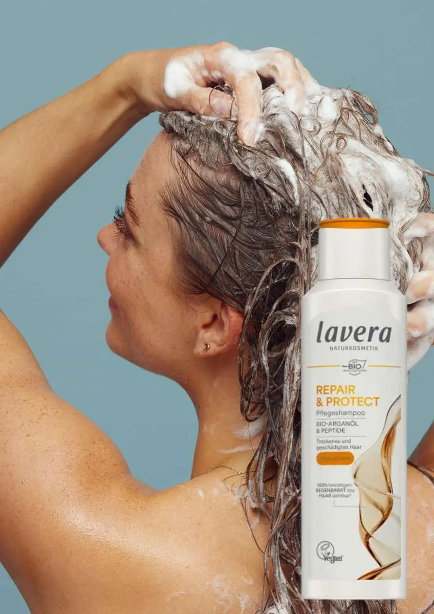 Visage femme trois quart dos qui se lave les cheveux avec photo shampoing soin Repair & Protect Lavera